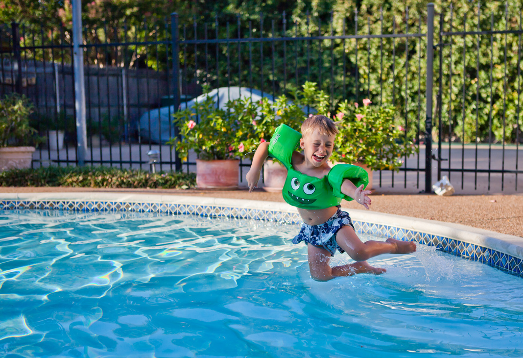 boy jumping into a swimming pool
